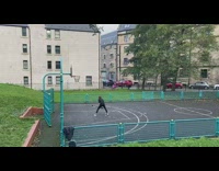 Guy dribble basketball court blue fence headphones
