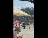 Girls balance pineapple on head at beach