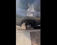 Man shows parked car with stolen tires