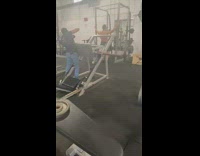Shirtless guy back muscles hold equipment gym