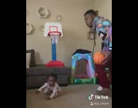 Guy dribbles toy basketball pushes baby girl 