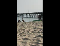 Two girls bend back raise leg beach