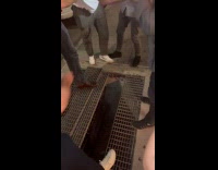 Man being pulled out from subway grate