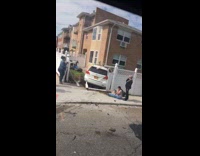 People observing the scene of car accident where car through fence