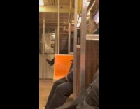 Man black jacket pullups in subway handrail