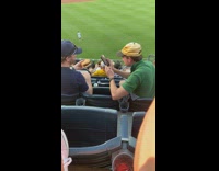 Guy on bleachers burger food review baseball