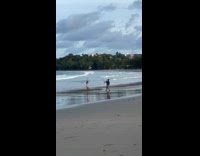 Woman white beach outfit dances at beach
