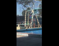 girl in pink  jumping into pool belly flops 