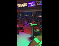Woman pose with bowling ball on floor