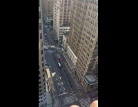 Woman sitting on window ledge of high rise apartment