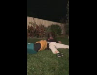 Collab scorpionmasters - Two girls wrestle on backyard grass, girl in yellow green jersey flips over and scorpions