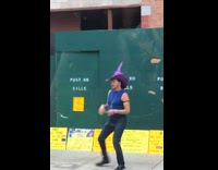 Man wearing witch hat dancing on sidewalk