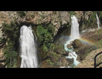 Small rainbow near three waterfalls windy mountain
