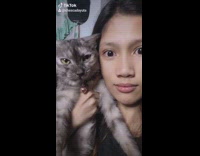 Girl holds cat opens mouth face filter