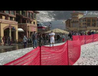 Girl wearing white snowsuit poses by plaza 