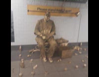 Man sits at station covered in  gold 