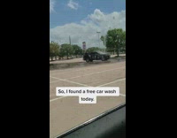 Cars driving through broken water sprinkler 