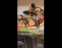 Guy shows his mom got seafood pizza 