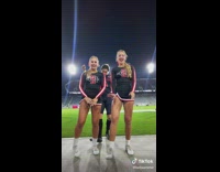 Two cheerleaders doing dance challenge football player comes behind