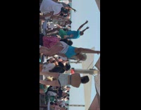 A bunch of women dancing to gasolina on the top of benches at beach