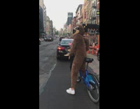 person in brown sloth costume on bike