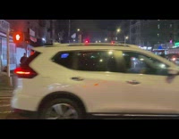 Trash burning inside of a wire mesh trashcan on intersection 
