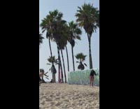 Woman in maroon shorts flexes butt in front of the wall