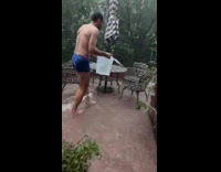 Man collect water from flooded balcony storm