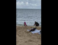 Woman with red hair in bikini split kneel at the beach