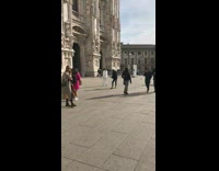 Lady wearing white poses by historic church 