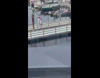 Woman in black tube top poses by the docks