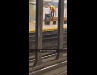 Worker in orange vest stands on bench and takes out fire in trash can 