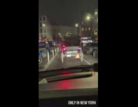 Man in a car trailing behind a buggy