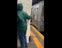 Man green hoodie hold door train station
