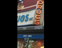 Store called Drugs Inc. with blue and red neon sign