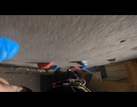 Guy jumps down grey rock climbing wall 