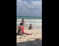 Girl circles friend with phone at beach