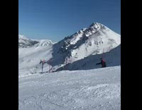 Guy jumps and spins on white skis 
