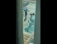 Bikini girl straddles metal railing by pool 