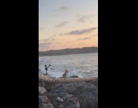 Woman uses struck bowl for beach video