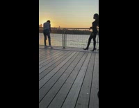 Woman black high heels pier cameraman moves 