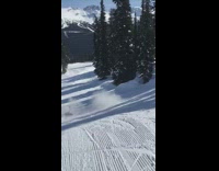 Skier jumps off ramp, flips sideways, and falls down