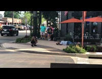 Guy lays on stomach sidewalk american flag