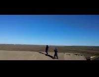 White jet flies by guy recording outside 