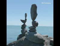 Two towers of stacked rocks by ocean 