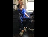 man in blue smoking with black luggage