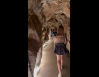 Woman tours cave filmed by friend behind