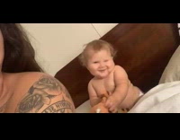 Baby with toy smiles and poses for camera