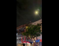 Woman stands at balcony sings American song