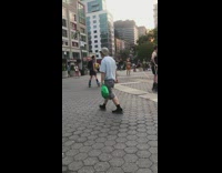 2 guys rollerblade around guy wearing traffic cone 